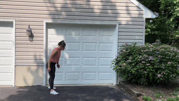 trainer doing inchworms outside in front of garage