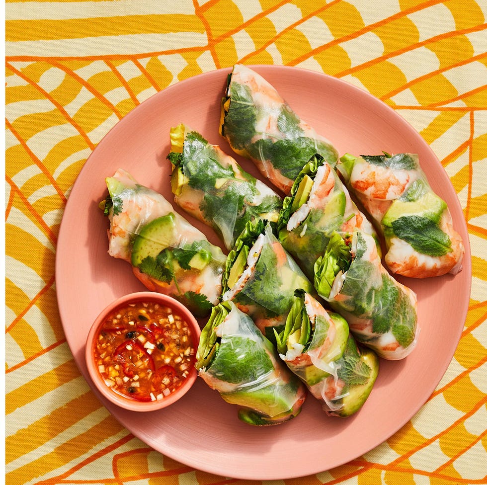 a plate with pasta and a bowl of spring rolls
