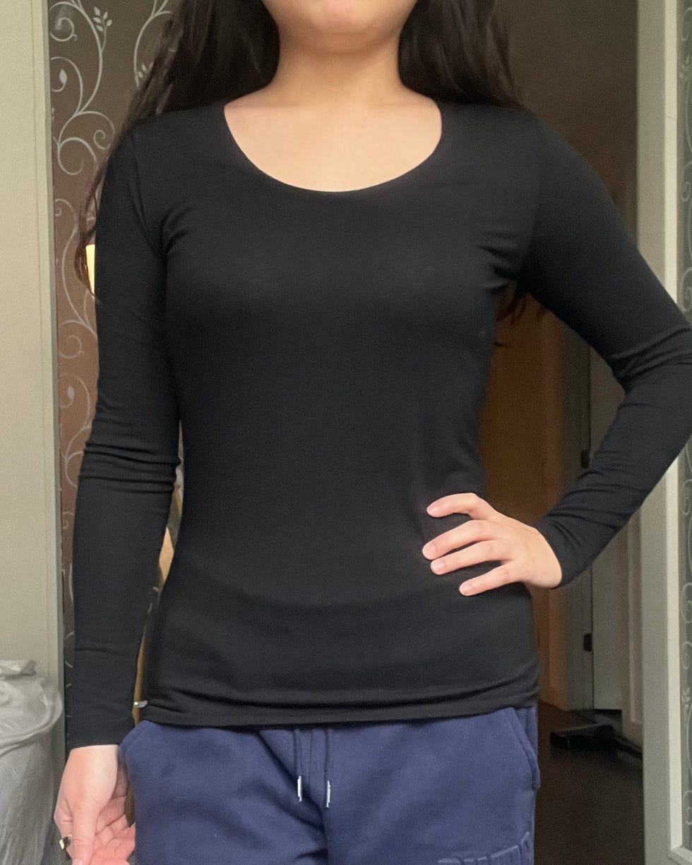 person wearing a black longsleeve top with a round neckline and navy blue sweatpants