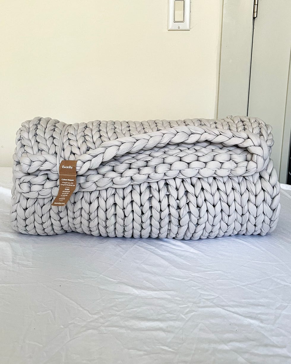 knitted blanket rolled and placed on a surface