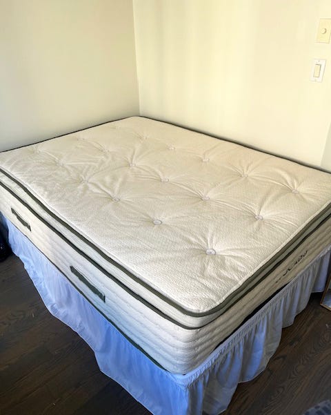 mattress set on a bed frame with a white skirt