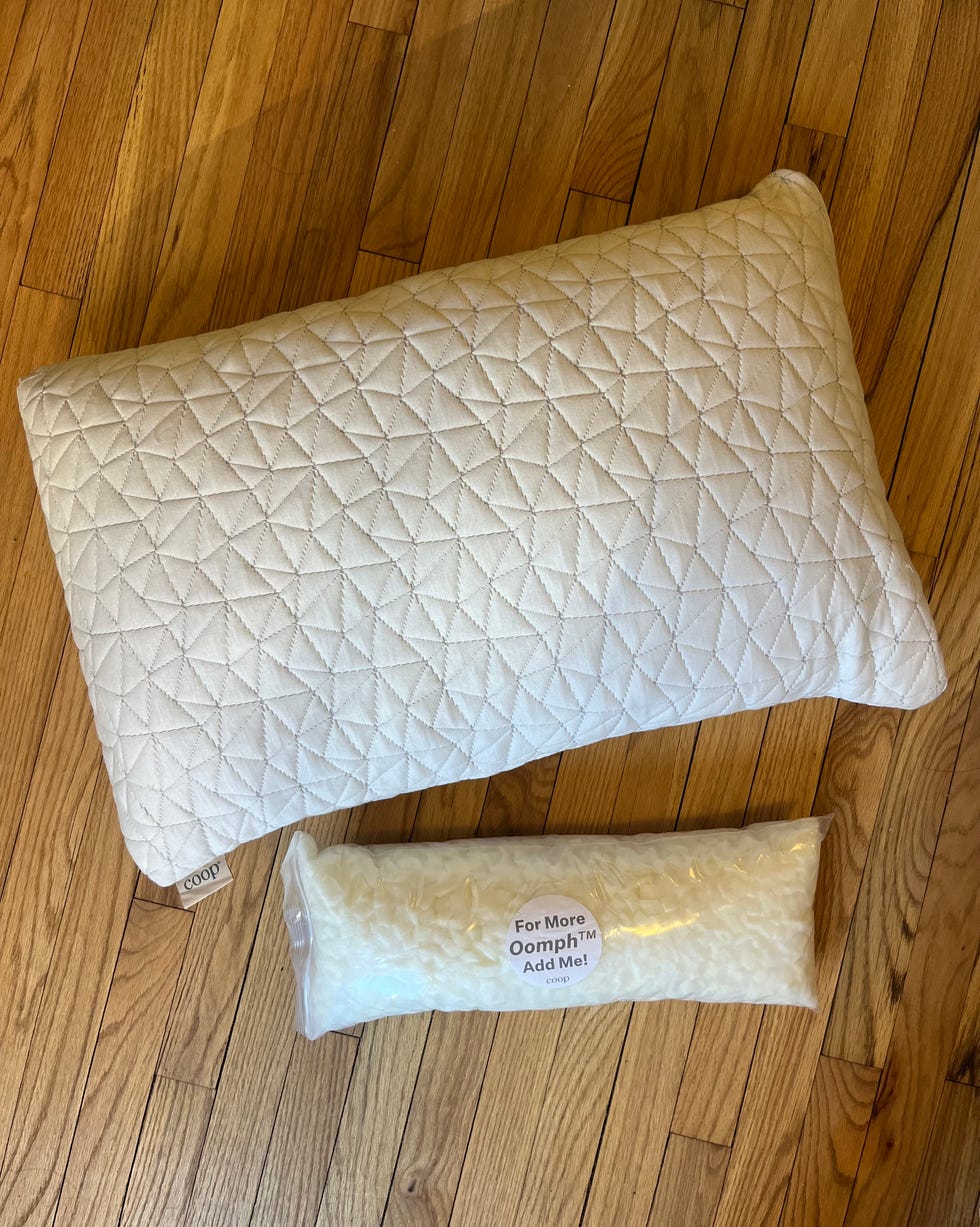 quilted pillow and bag of filling on wooden floor