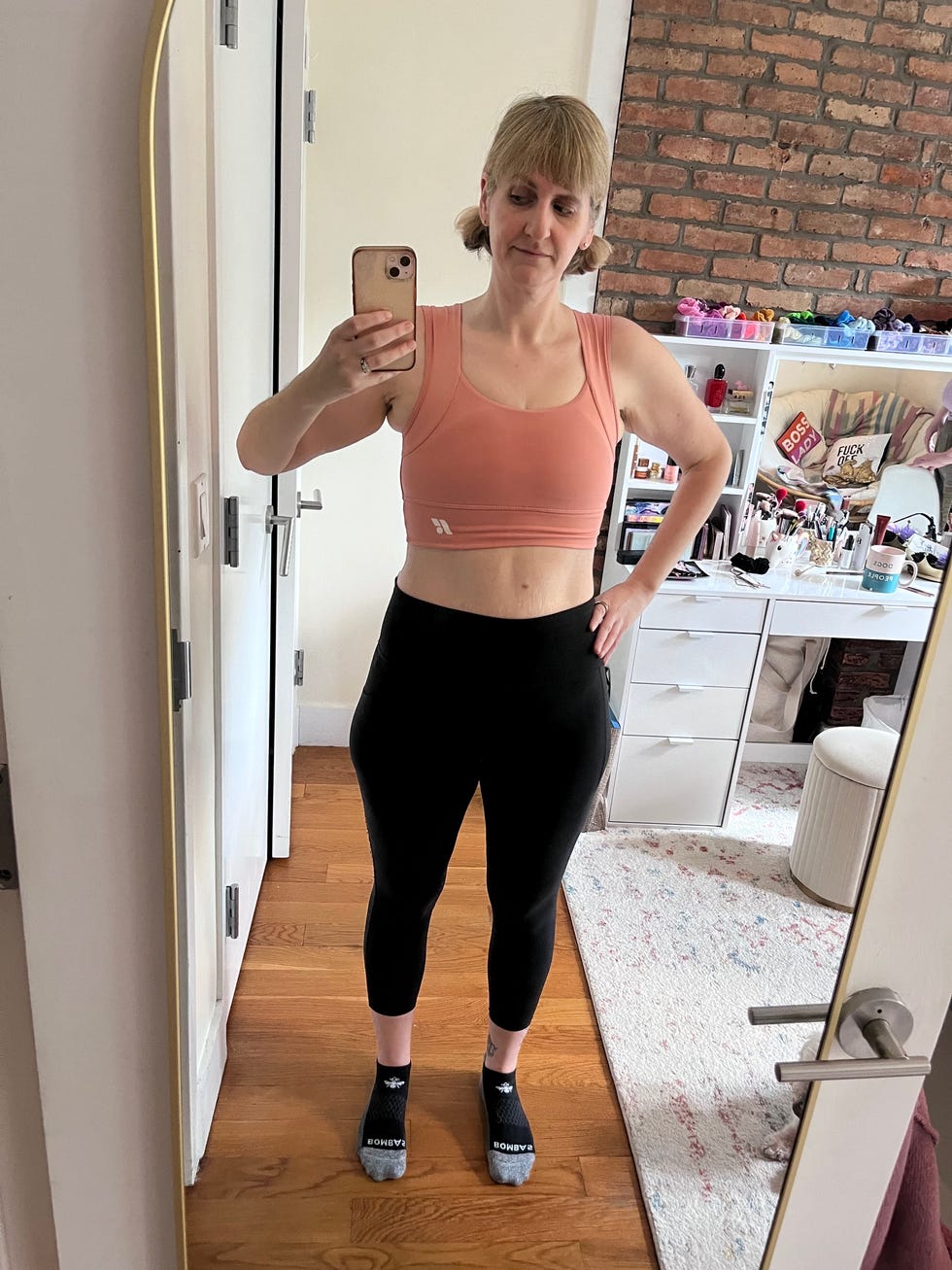 Person posing in activewear with a casual home background.