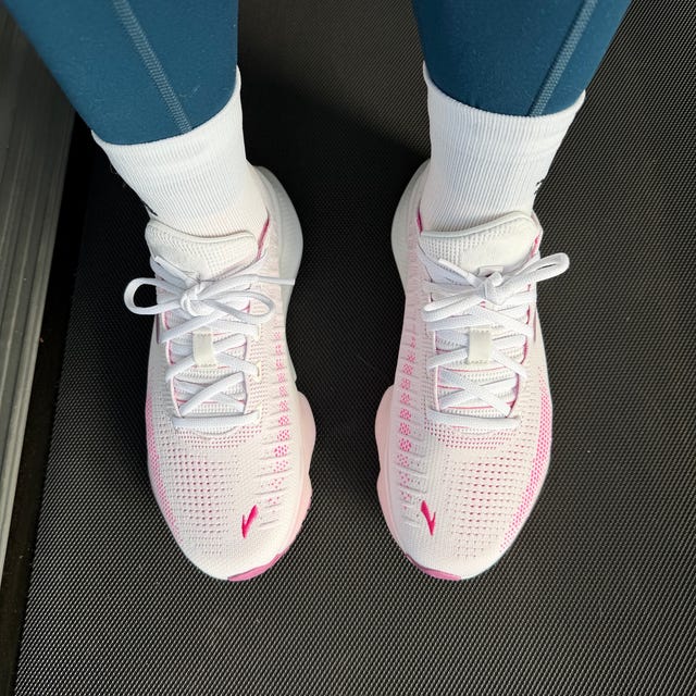 Footwear with a sporty design worn with athletic leggings on a gym floor.