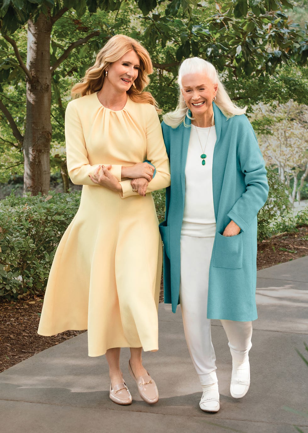 Two women walking together in a natural setting.