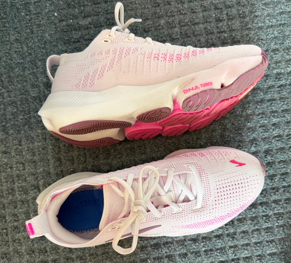 Pair of pink athletic shoes placed on a gray carpet.
