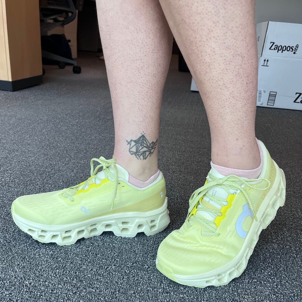 Footwear display featuring bright yellow athletic shoes and a tattoo.