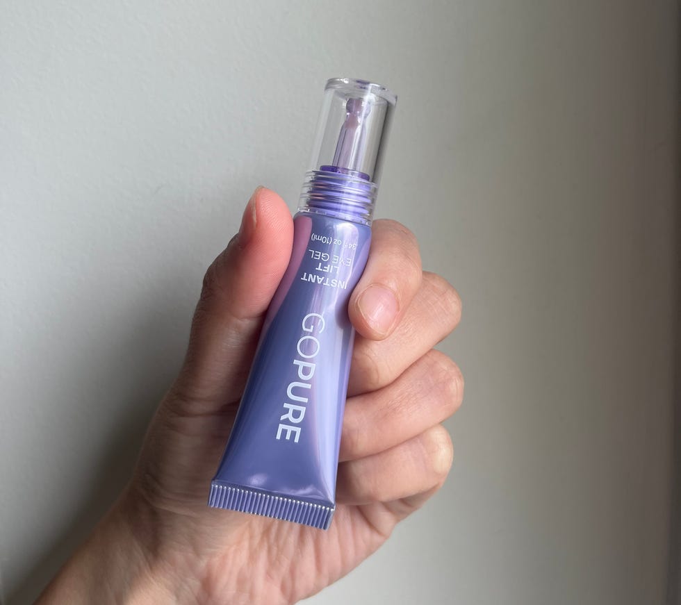 Hand holding a tube of eye gel.