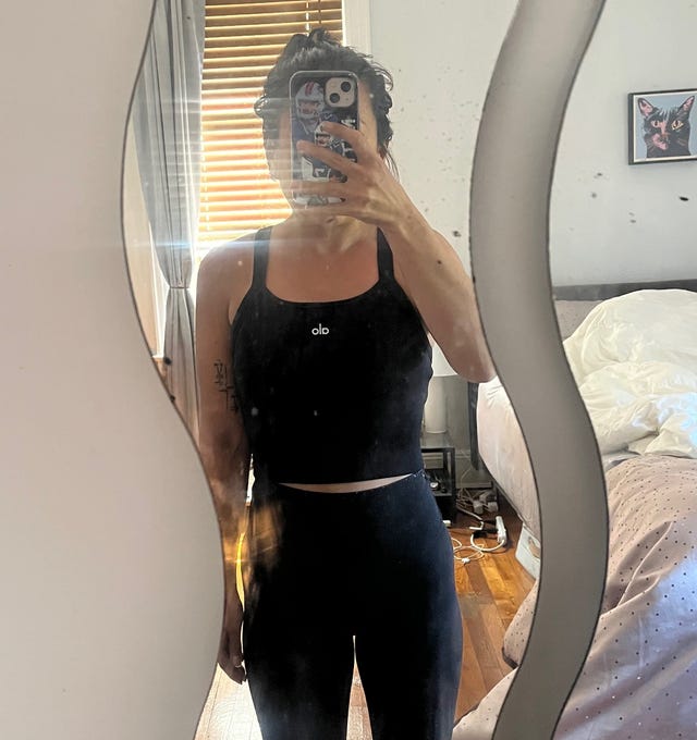 Person in workout attire standing in front of a mirror