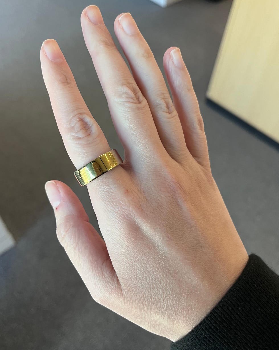 Hand wearing a gold ring.