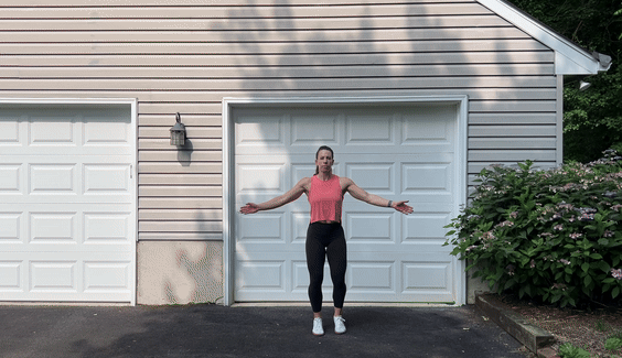 woman doing jumping jack outside in front of garage
