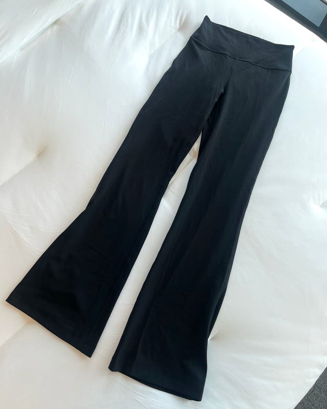Black flared yoga pants on a white surface.