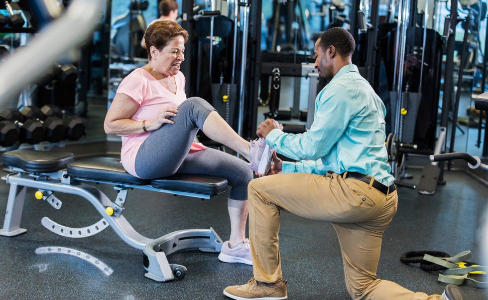 physical therapist examines senior woman with leg injury