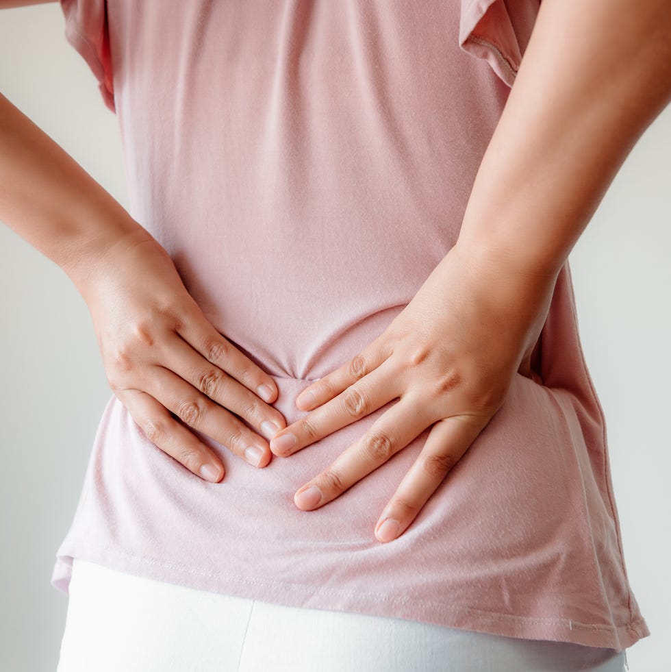 rear view of woman with back ache against white background