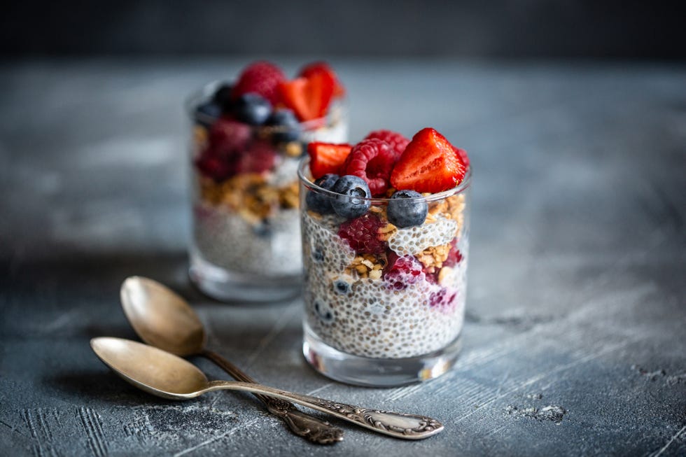 healthy vanilla chia pudding in glass with fresh berries on vintage concrete table copy space banner