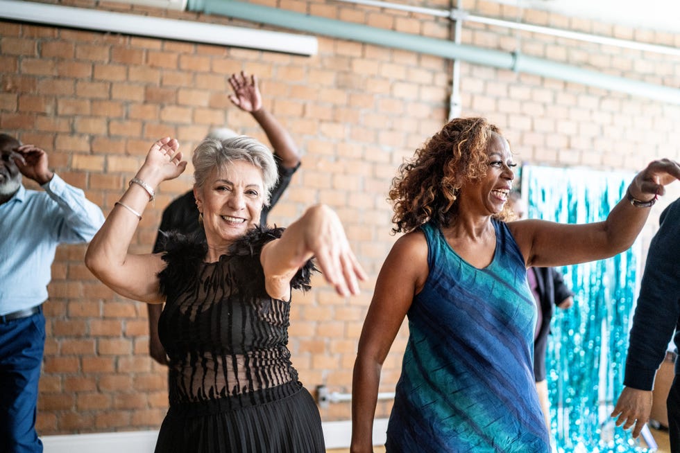 portrait of a senior woman dancing with her friends on a dance hall
