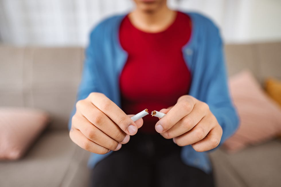 young woman breaking cigarette and quitting smoking, concept of stop smoking photo