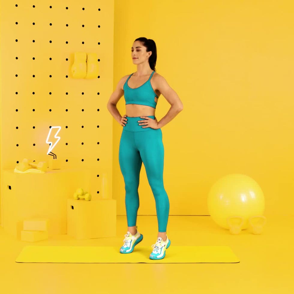 A woman in athletic wear stands confidently on a yellow workout mat against a bright yellow background with fitness equipment.