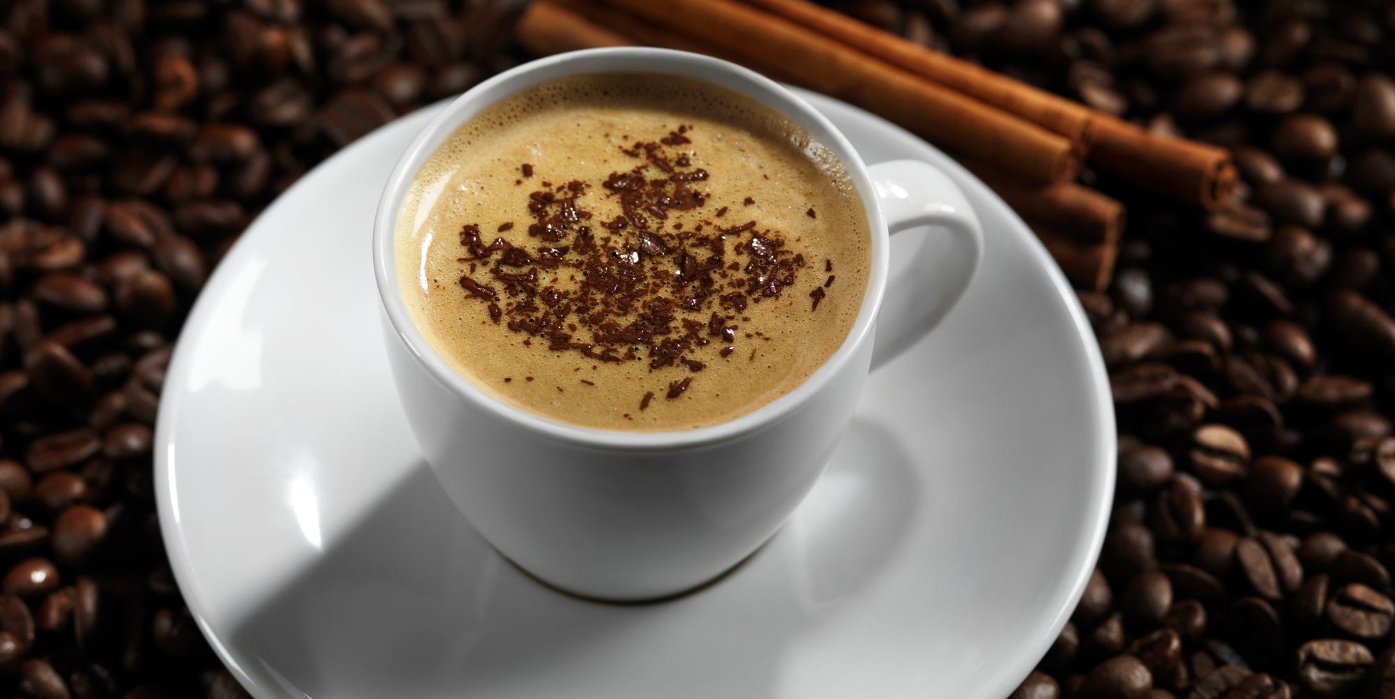 Cup of coffe latte with chocolate on coffee beans background