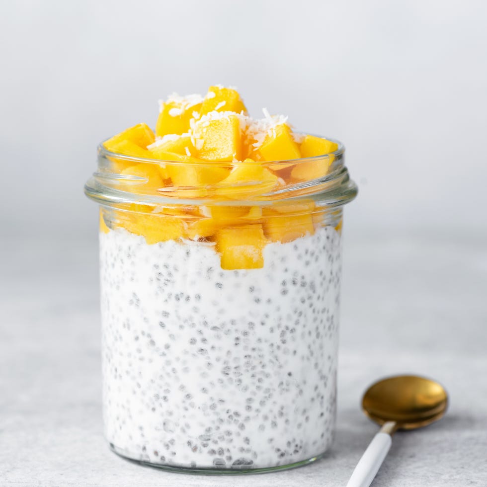 Close up of chia seed pudding topped with mango pieces in jar