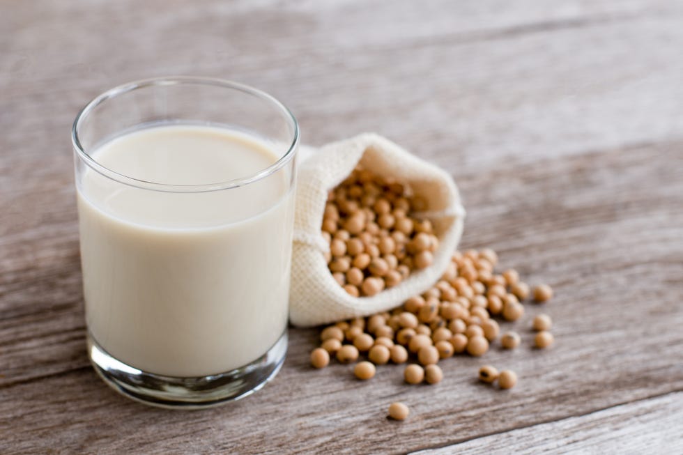 glass of soy milk isolated on wooden table background