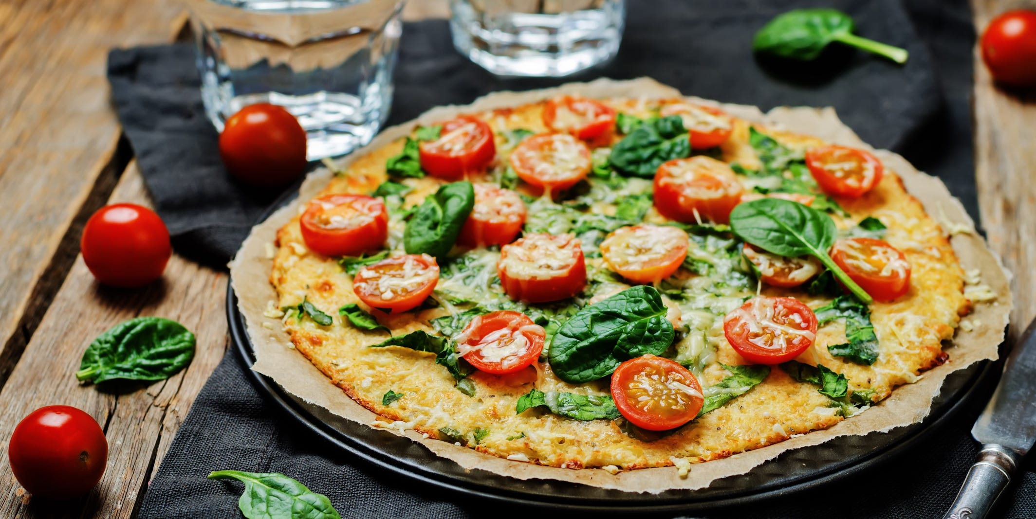 Cauliflower pizza crust with tomato and spinach