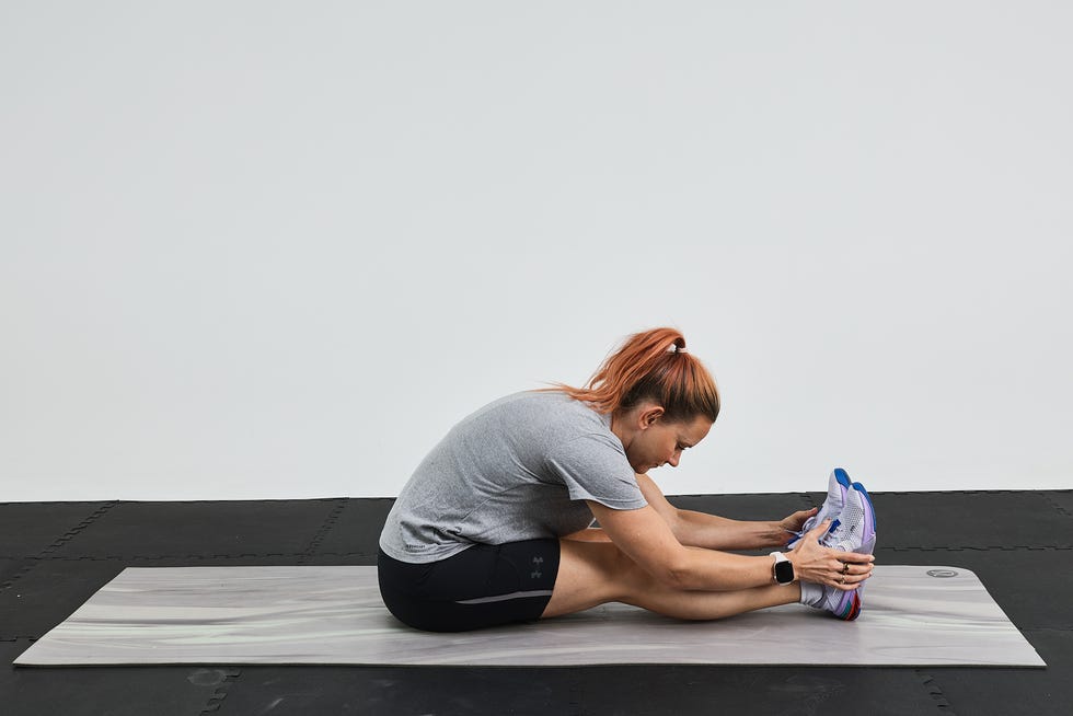 Person stretching on a yoga mat, reaching for their toes, with a focus on flexibility and exercise.