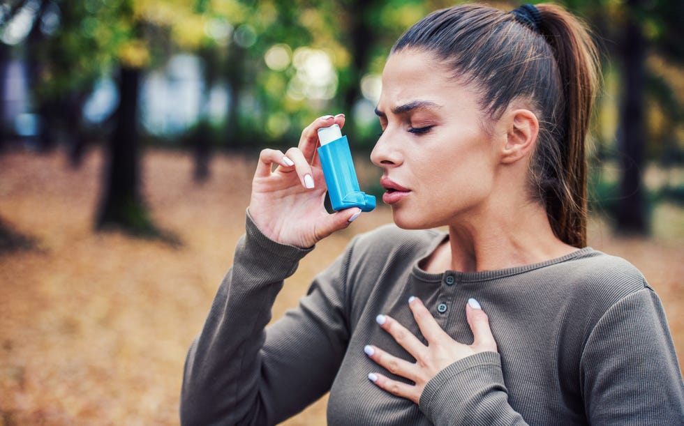 woman using asthma inhaler