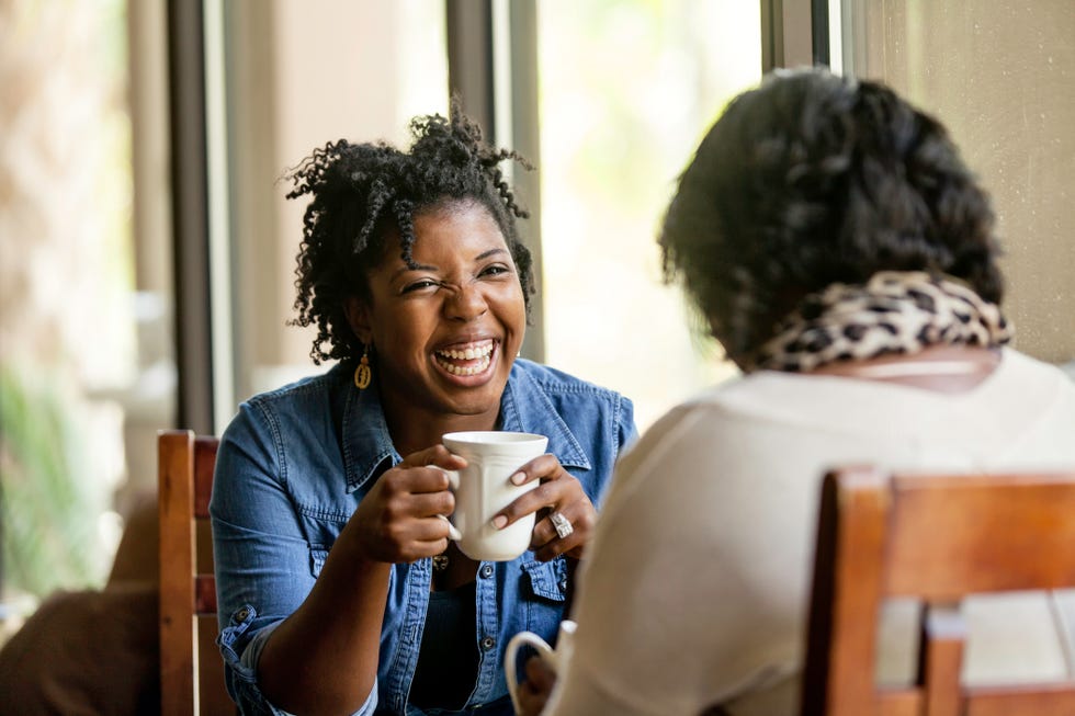 attractive african american women have a good time with a close friend drinking good coffee