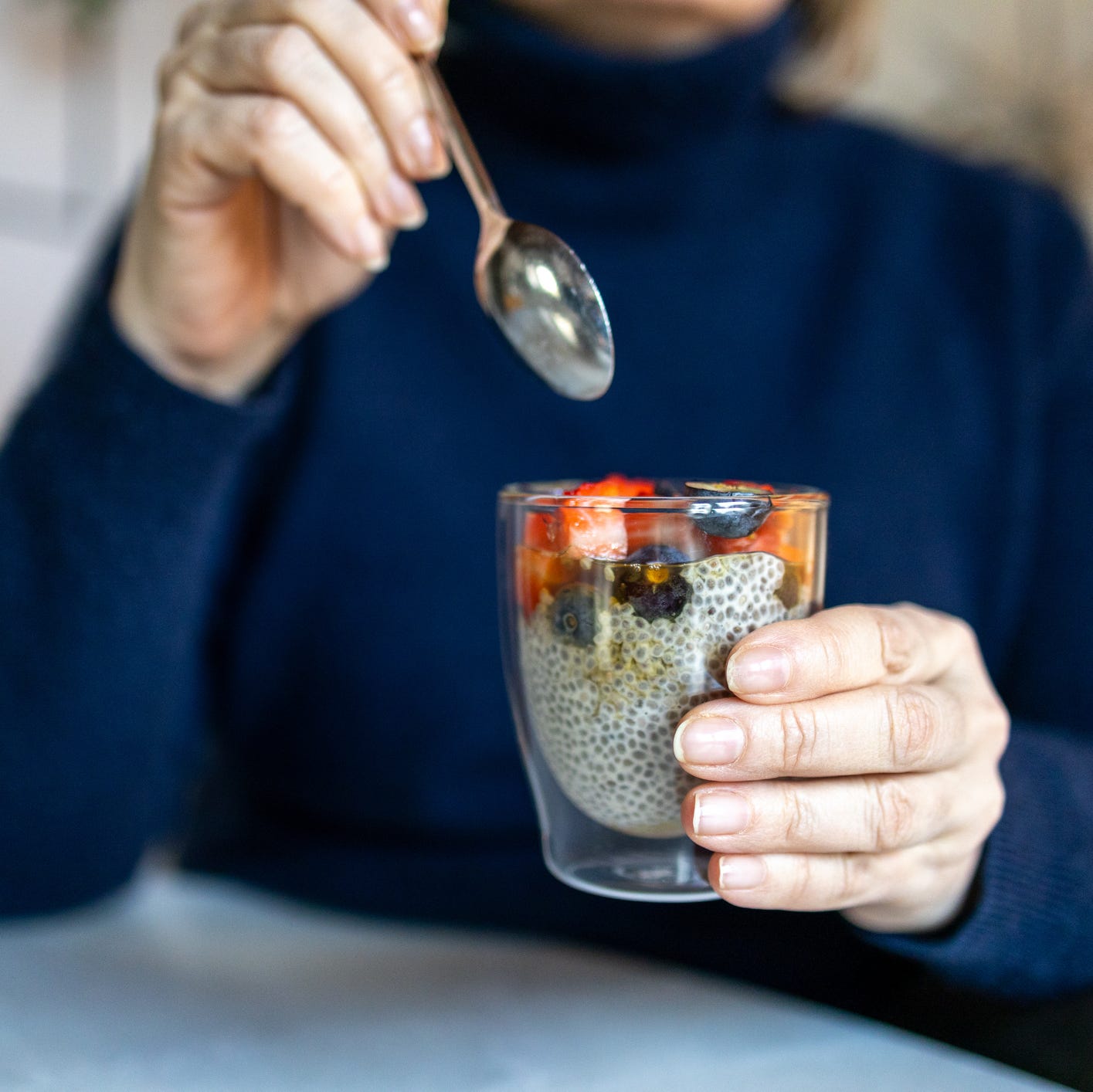 Woman holding a healthy chia seed pudding with fresh berries for breakfast. Superfood. Healthy eating Woman holding a healthy chia seed pudding with fresh berries for breakfast. Superfood. Healthy eating