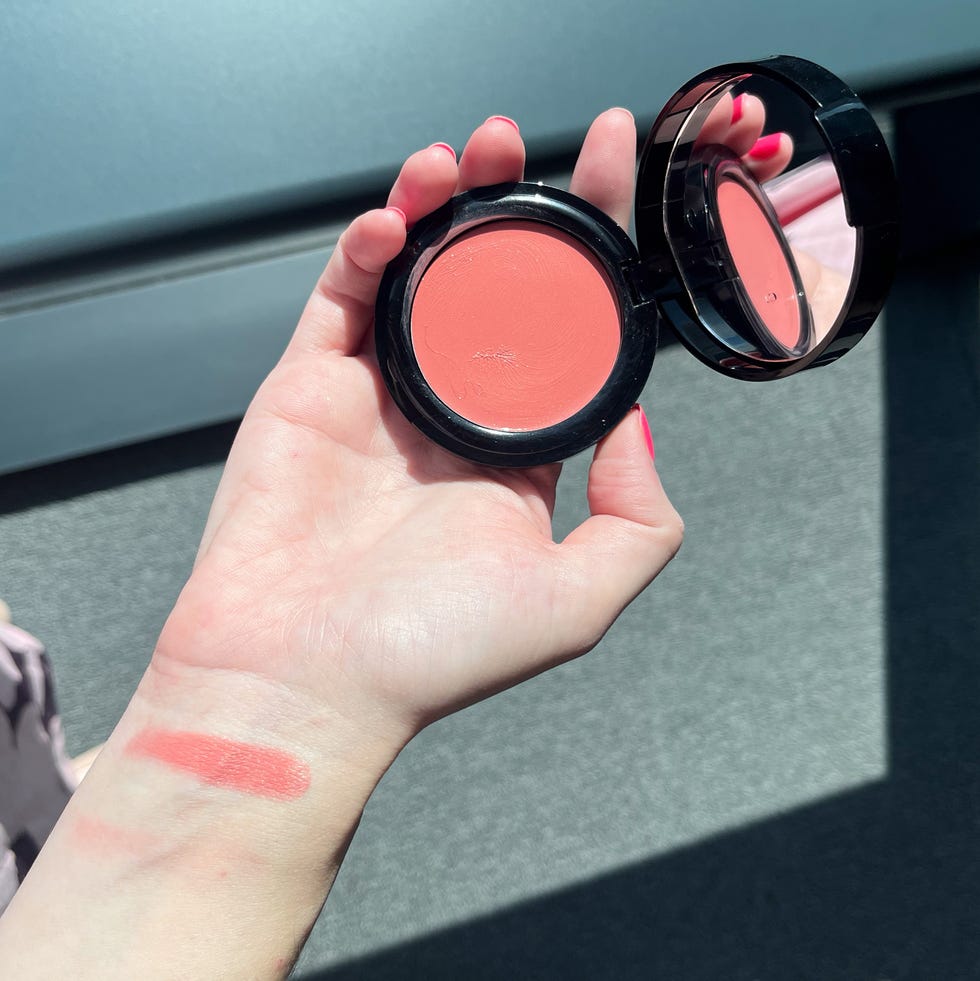 laura gellar wonder balm blush compact held in hand with swatch on wrist in natural light.