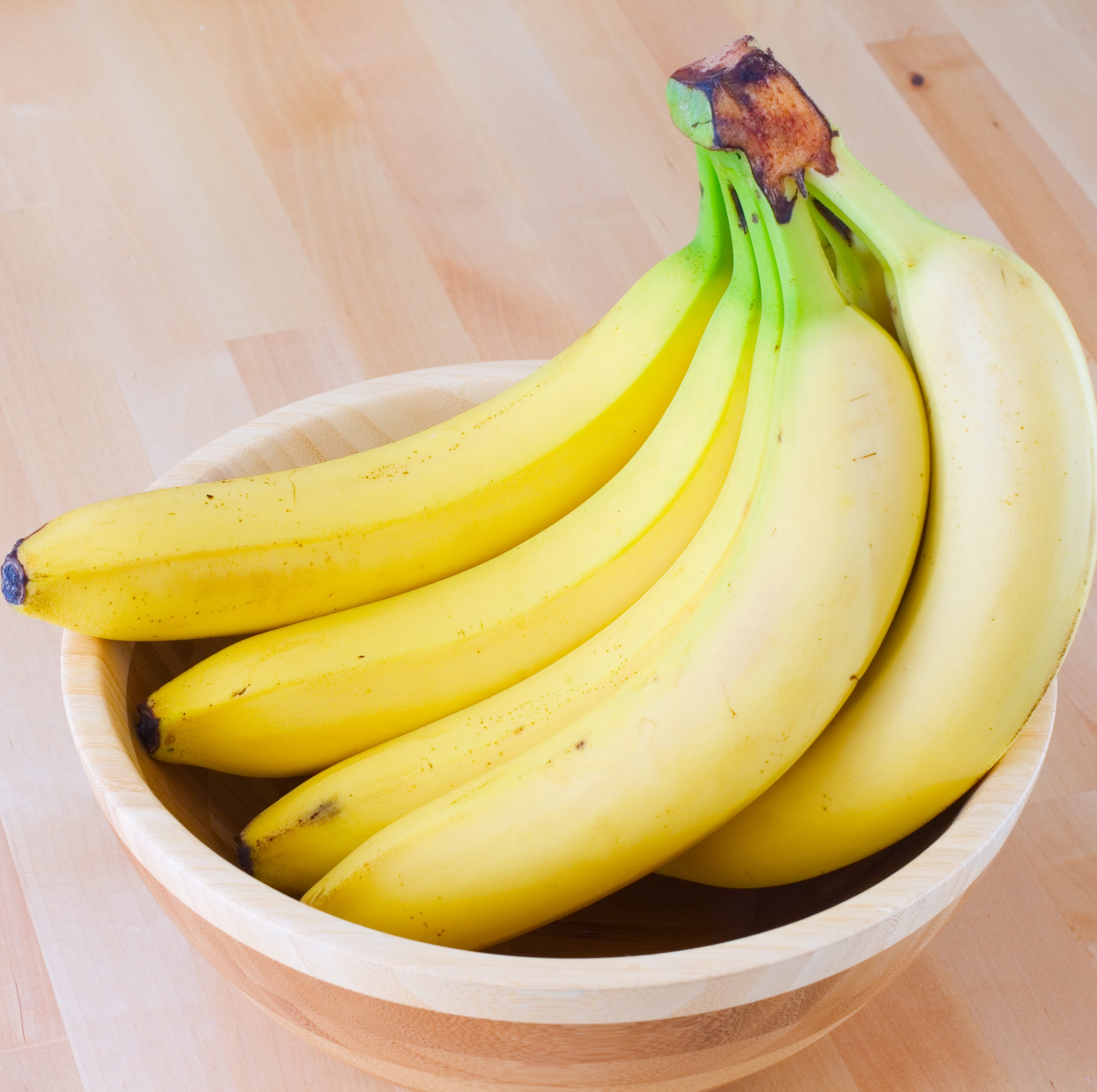 Ripe bananas in a wooden bowl Ripe bananas in a wooden bowl
