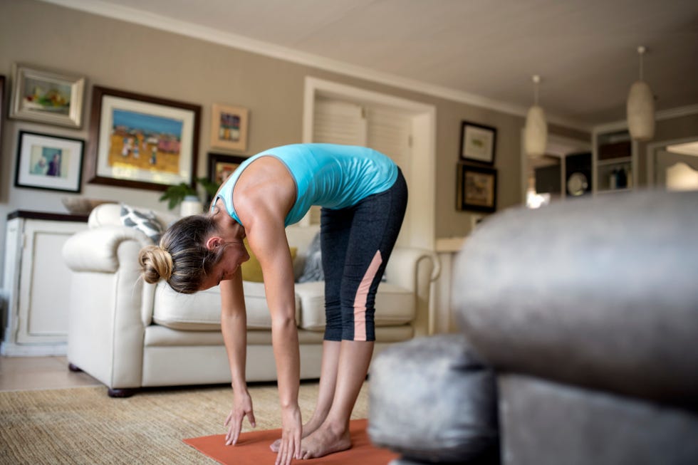 woman practicing yoga in living room at home