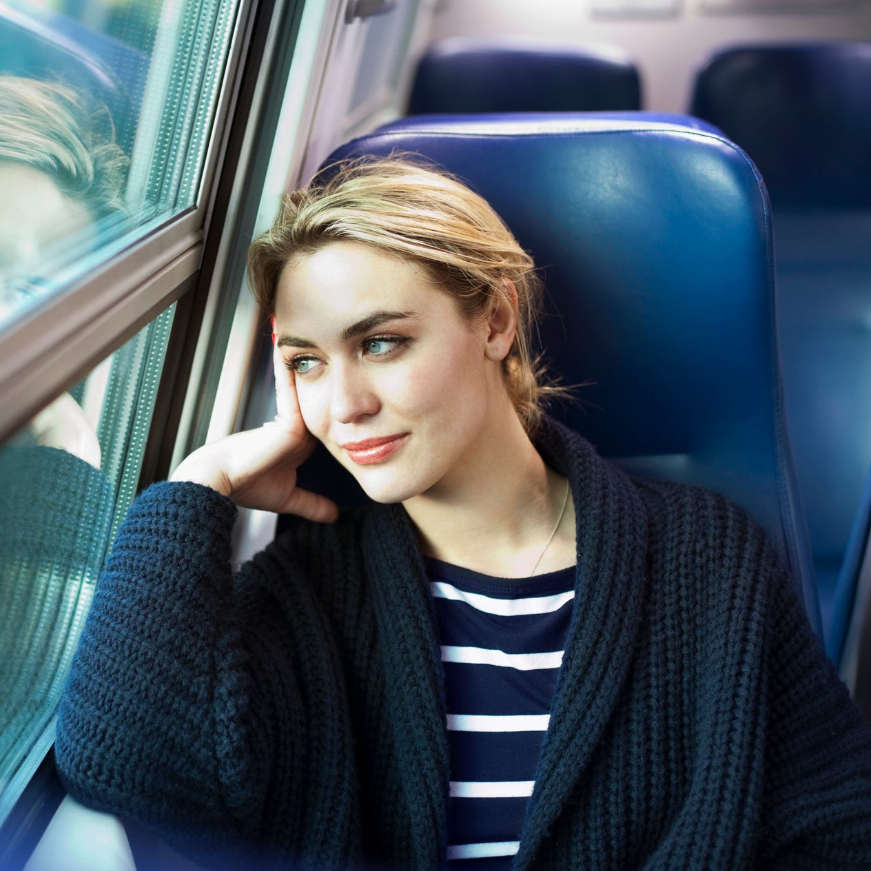 young woman on a train looking out the window